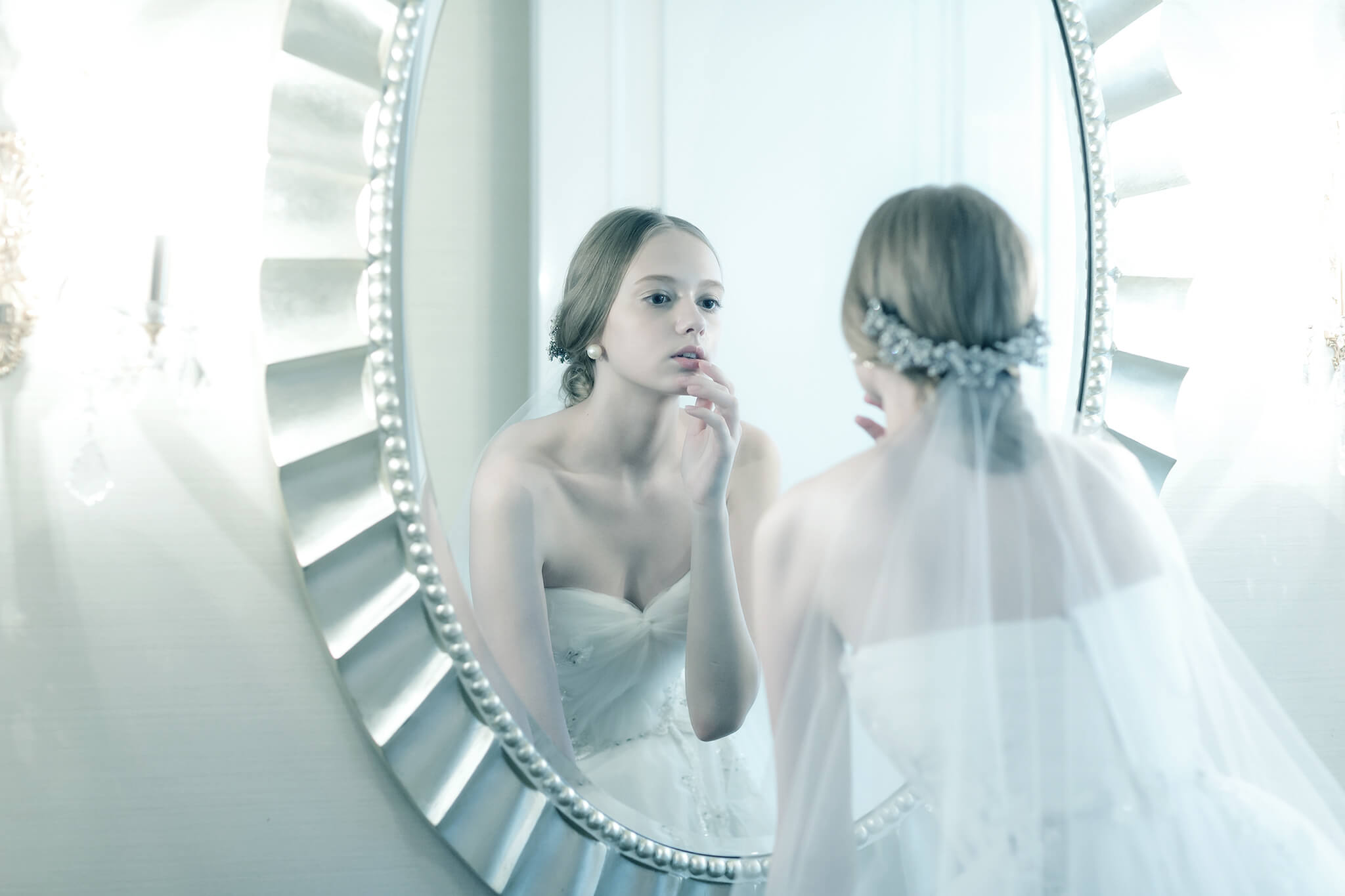 大きな鏡の前で化粧直しをする新婦のイメージ写真